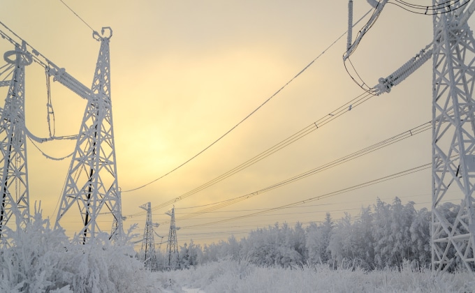 Power lines and towers covered in snow.