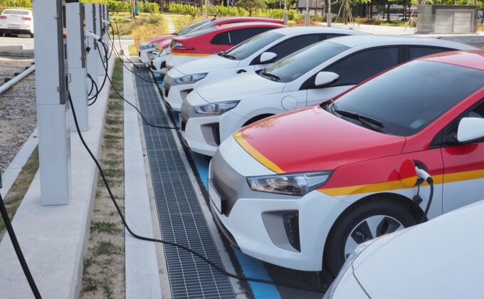 row of electric cars charging||row of electric cars charging