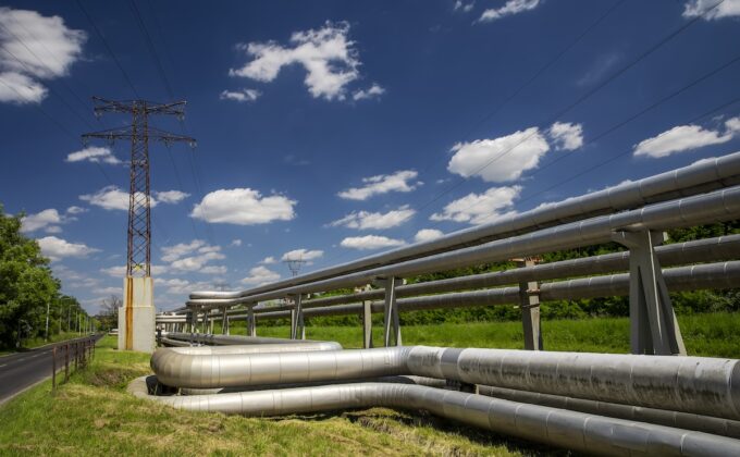 Electric transmission wires and district heating tubes under blue skies