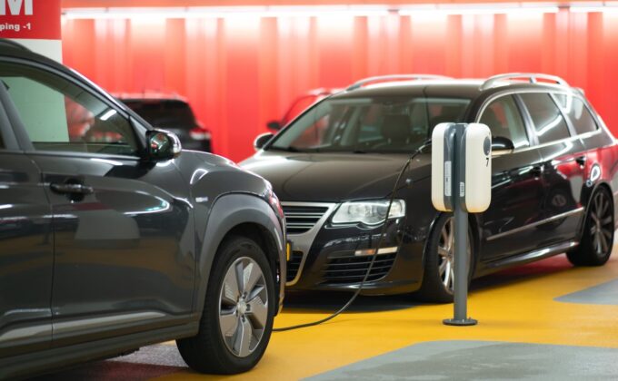 black electric cars charging inside parking garage|Black electric cars charging inside parking garage|Electrification: Using more to emit less|Electrification: Using more to emit less