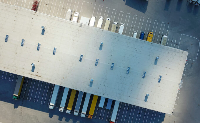 Aerial view of delivery trucks at a warehouse|Graphic showing the load curve of trucks loading at depot and best times for charging|Aerial view of trucks at a warehouse