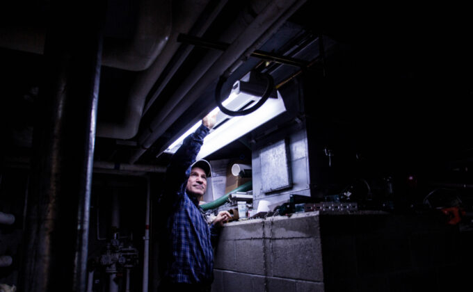 man installing fluorescent light tubes