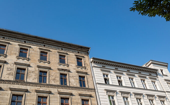 Altes Gebäude neben einem neuen Gebäude unter blauem Himmel