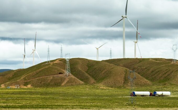 wind turbines on low brown hills|