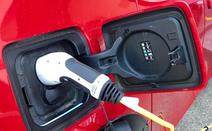 plug attached to red electric vehicle