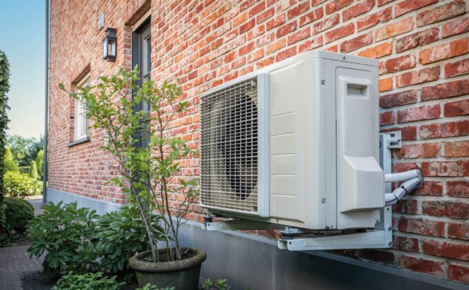 A heat pump installed alongside a brick wall