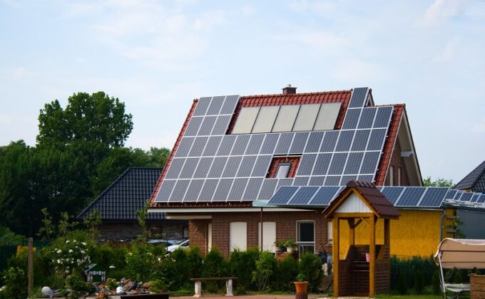 energy efficient house with solar panels and a garden against blue sky||energy efficient house with solar panels and a garden against blue sky