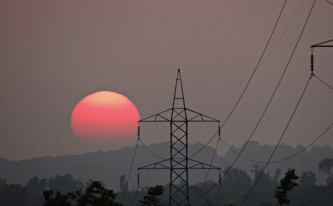 Power lines silhouetted against gray sky and setting sun|Power lines silhouetted against gray sky and setting sun|Graphic of relationships between political economy and electricity reforms