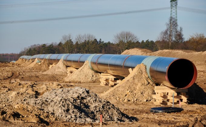 gas pipeline on construction site in Germany surrounded by dirt trees and a transmission tower