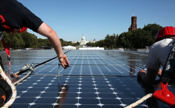 solar panels being installed with U.S. Capitol in background