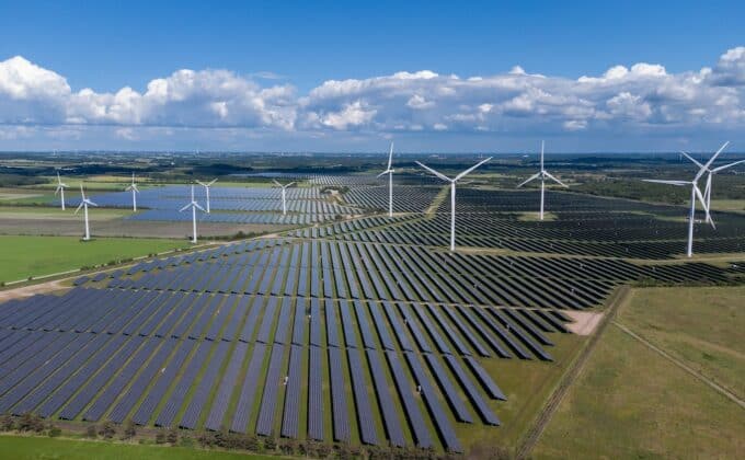 Solar panels and wind turbines in a field.