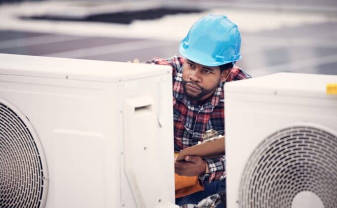 A technician inspects heat pump units