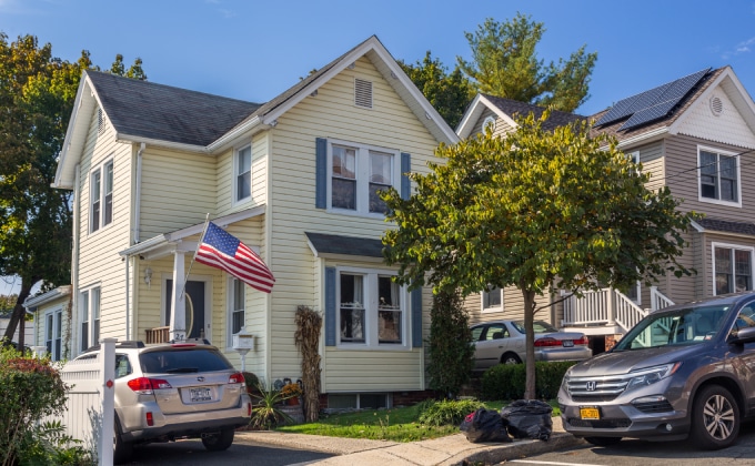 Two houses in New York with rooftop solar panels.