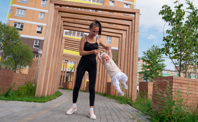 young woman swinging laughing baby