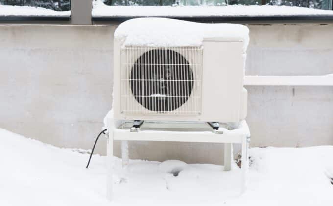 A heat pump outdoor unit with snow on top