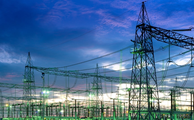 An electric substation in Brazil is lit up at dusk.