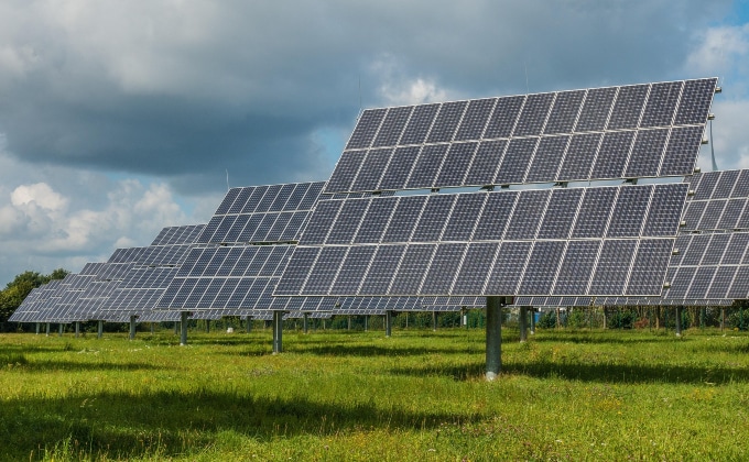 Ground-mounted solar panels in a green field