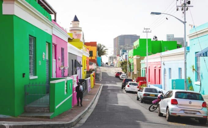 cars parked beside green and white concrete building during daytime in bokaap, cape town, south africa