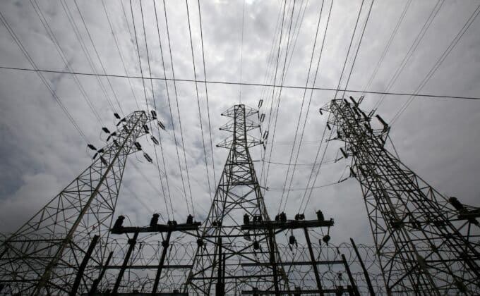 High-voltage power lines stretch across the sky outside a Tata Power substation in the suburbs of Mumbai, India, showcasing the city's electrical infrastructure.