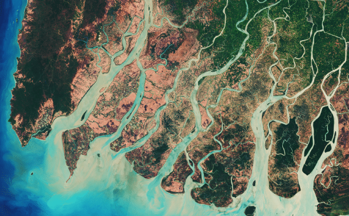 An aerial view of a river delta, with multiple water sources converging into a larger body of water.