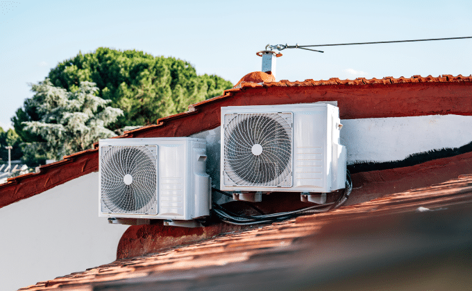 A pair of heat pump units on the tiled roof of a residence in Italy.